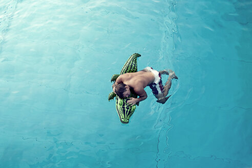 Young man with swim toy floating in water, view from above - PAF000551