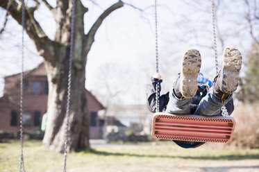 Germany, Mecklenburg-Western Pomerania, Ruegen, little boy swinging at playground - MJF000935