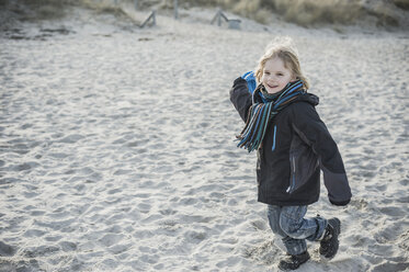 Germany, Mecklenburg-Western Pomerania, Ruegen, smiling little boy running on beach in winter - MJF000958