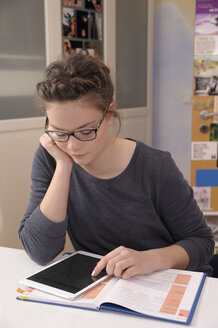 Schülerin macht Hausaufgaben mit digitalem Tablet - BTF000319