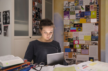 Female pupil doing homework with digital tablet - BTF000327