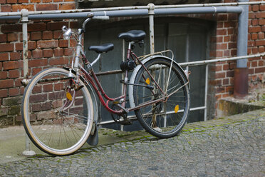 Deutschland, Sachsen, Leipzig, altes Fahrrad am Geländer lehnend - HCF000024