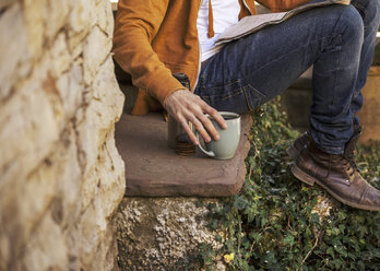 Junger Mann sitzt auf den Stufen und macht Kaffeepause, Teilansicht - EBSF000084