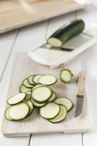 Geschnittene Zucchini auf Schneidebrett, Mandoline, Selbstgemachte Zucchini-Chips, lizenzfreies Stockfoto