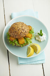 Burger mit Fischstäbchen und Kräuterquark auf Teller - ECF000451