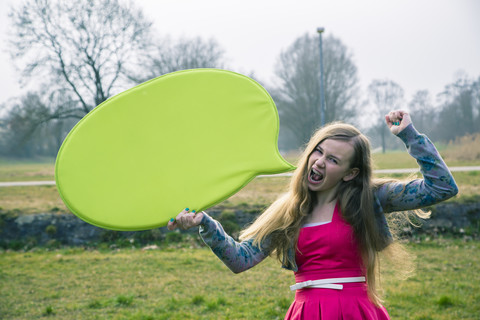Deutschland, Landshut, Weiblicher Teenager mit grüner Sprechblase, lizenzfreies Stockfoto