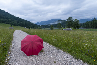 Deutschland, Bayern, Werdenfelser Land, Roter offener Regenschirm auf Wanderweg am Geroldsee - RJF000031