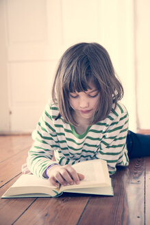 Porträt eines kleinen Mädchens, das zu Hause ein Buch liest - LVF000845