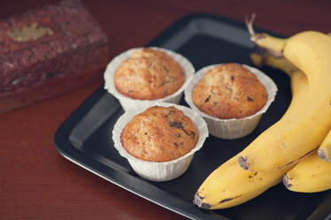 Bananenmuffins mit Walnuss- und Schokoladensplittern auf dem Teller - BR000134