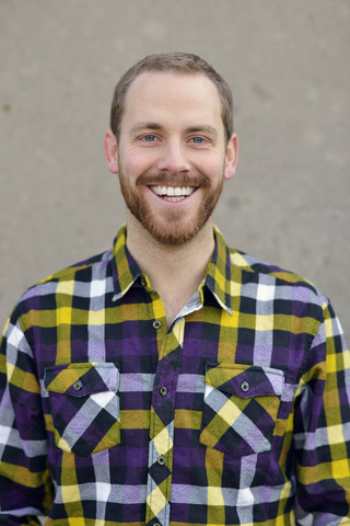 Portrait of laughing young man wearing checkered shirt stock photo