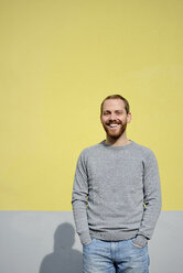 Porträt eines lachenden jungen Mannes vor einem gelben Hintergrund - BR000174