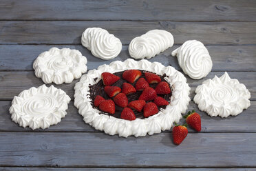 Meringues und Baiser gebackenes Gebäck mit Schokoladenglasur garniert mit Erdbeeren auf grauem Holz - CSF021021