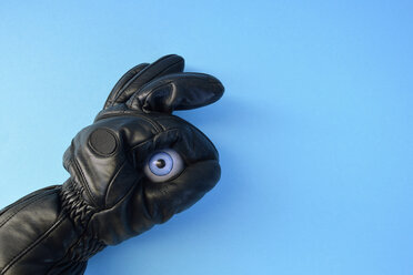 Lederhandschuh und Augapfel aus Plastik vor blauem Hintergrund - AXF000639