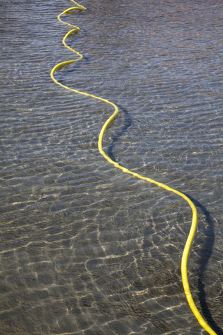 Yellow hose lying in a pool stock photo