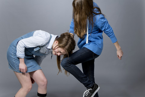 Teenager-Mädchen, das seine Schwester tritt, lizenzfreies Stockfoto