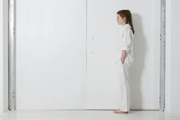 Teenage girl wearing white clothes standing in white room - MAEF008177