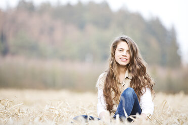 Porträt eines Teenagers auf einem Feld sitzend - MAEF008266