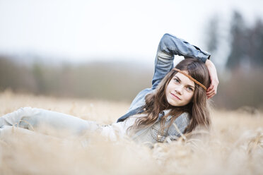 Porträt eines auf einem Feld liegenden Mädchens im Teenageralter - MAEF008267