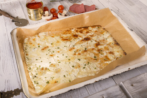 Backblech mit Low-Carb-Pizzaboden auf Holztisch mit Mozzarella, Frischkäse und Oregano - CSTF000168