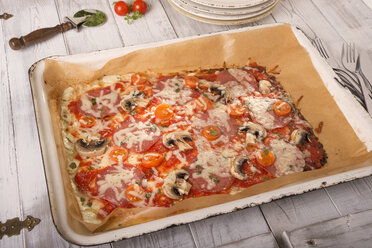 Backblech mit gebackener Low-Carb-Pizza auf Holztisch - CSTF000171