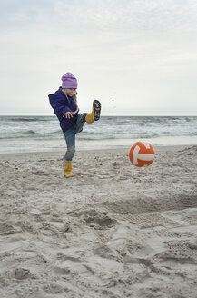 Dänemark, Jütland, Vejers Strand, Mädchen kickt Ball am Strand - JBF000086