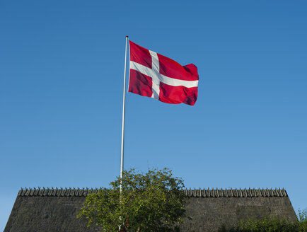 Dänemark, Insel Mon, dänische Flagge, reetgedecktes Dach im Hintergrund - JBF000081