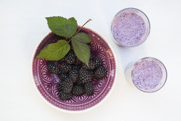 Schale mit Brombeeren (Rubus sectio Rubus) mit Brombeerblatt und zwei Gläser Brombeer-Smoothie - LVF000859