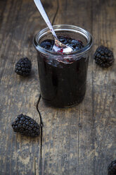 Preserving jar of blackberriy jelly and blackberries (Rubus sectio Rubus) on wooden table - LVF000851