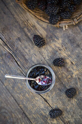 Korb mit Brombeeren (Rubus sectio Rubus) und Einmachglas mit Brombeergelee auf Holztisch - LVF000850