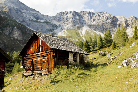 Österreich, Lungau, Holzhütte und Berge, lizenzfreies Stockfoto