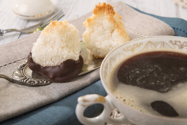 Two coco macaroons on cake server and cup of black coffee - CSTF000184