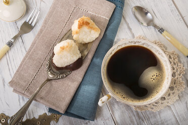 Zwei Kokosmakronen auf Tortenheber und eine Tasse schwarzer Kaffee, Blick von oben - CSTF000185