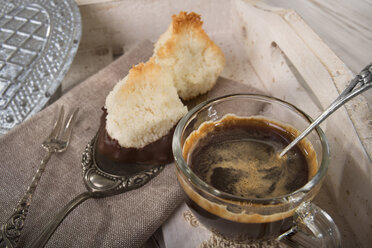 Zwei Kokosmakronen auf Tortenheber und eine Tasse Espresso - CSTF000187