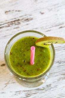 Glas Apfel-Kiwi-Smoothie auf Holztisch, Blick von oben - SARF000395