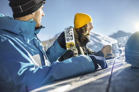 Österreich, Vorarlberg, Riezlern, Zwei Skifahrer im Biergarten, lizenzfreies Stockfoto