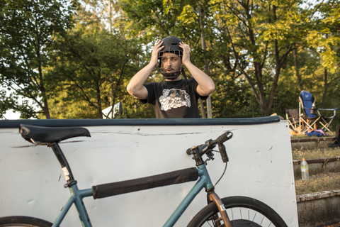 Germany, Hannover, Bike polo player putting on helmet stock photo