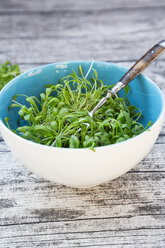Bowl of garden cress salad on grey wooden table, view from above - LVF000907