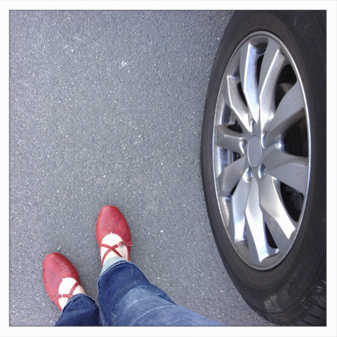 Rote Schuhe und Autoreifen, Fortbewegung, lizenzfreies Stockfoto