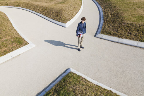 Germany, Baden-Wurttemberg, Teenage boy standing at crossing - WDF002412