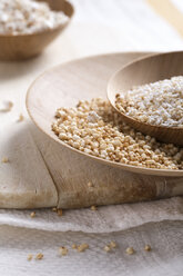 Schalen mit gepufftem Buchweizen, Quinoa und Amaranth auf Holzbrett und Küchentuch - MYF000262