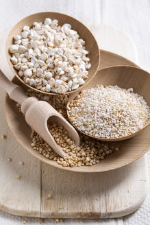 Schalen mit gepufftem Buchweizen, Quinoa und Amaranth auf Holzbrett und Küchentuch - MYF000263