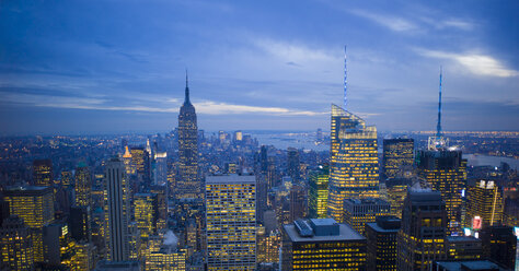 USA, New York, Manhattan, Blick auf beleuchtete Skyline in der Abenddämmerung - JWAF000018