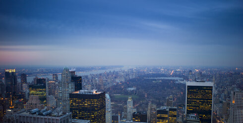 USA, New York, Manhattan, Blick auf beleuchtete Skyline in der Abenddämmerung - JWAF000013