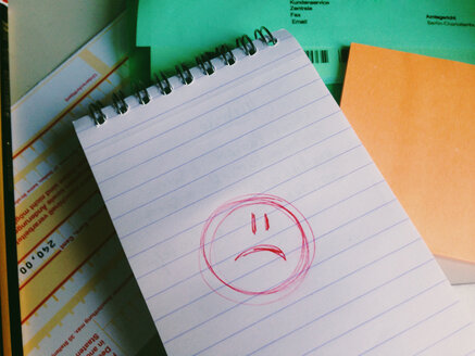 Trauriger Smiley auf Papier im Büro - MEAF000221