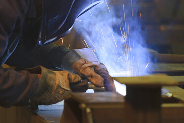 Man welding in a scrap metal recycling plant - LAF000814