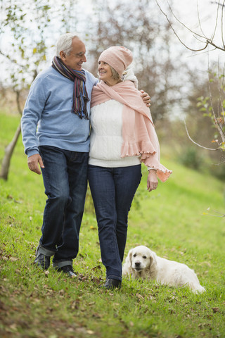 Älteres Paar beim Spaziergang mit Hund, lizenzfreies Stockfoto