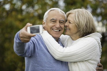 Portrait of happy senior couple taking self-portrait with smartphone - WESTF019215