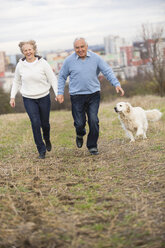 Lächelndes Seniorenpaar läuft Hand in Hand - WESTF019233