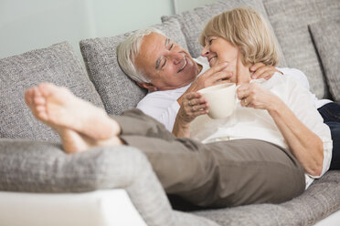 Senior couple in love on sofa in living room - WESTF019237