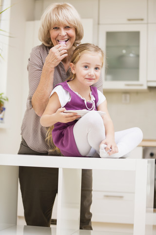 Kleines Mädchen und ihre Großmutter in der Küche, lizenzfreies Stockfoto